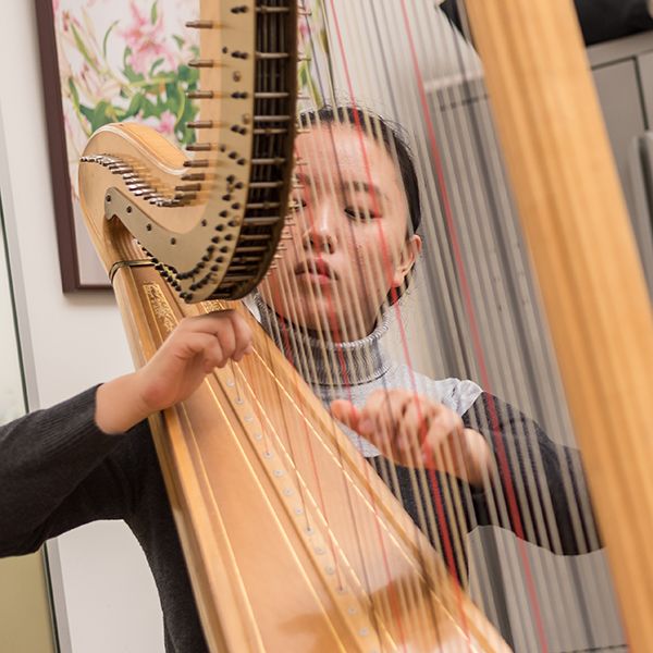 A student playing the harp