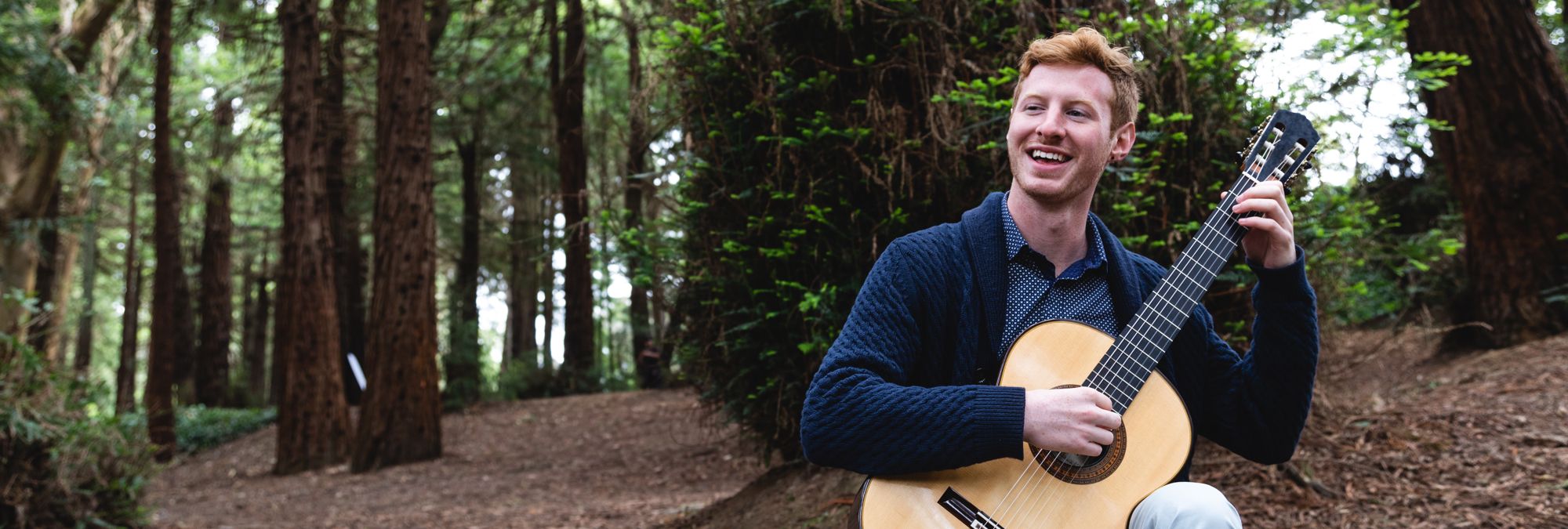 SFCM student playing guitar outside