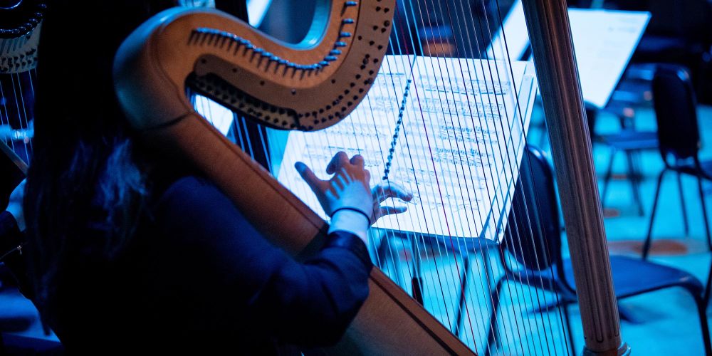 A SFCM student performing on the harp in the SFCM orchestra A SFCM student performing on the harp in the SFCM orchestra