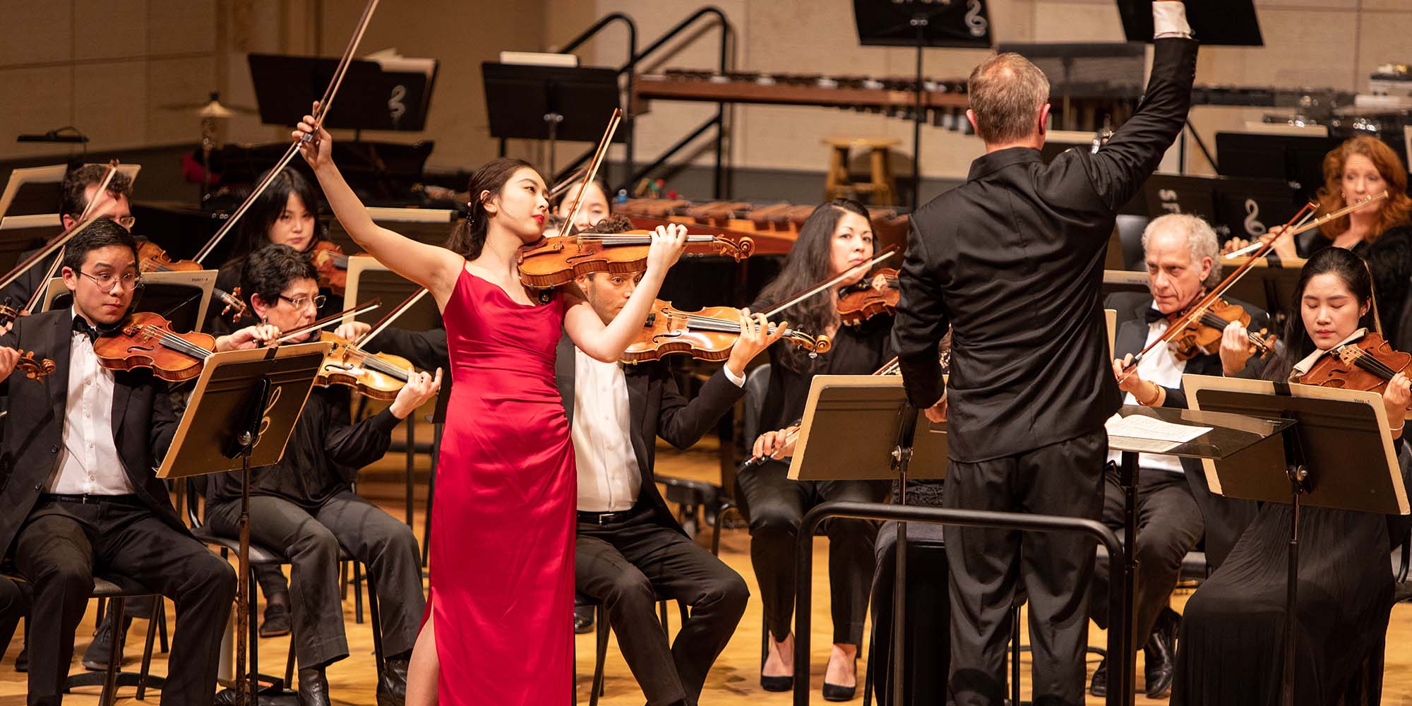 A SFCM student performing on the violin with the SFCM orchestra