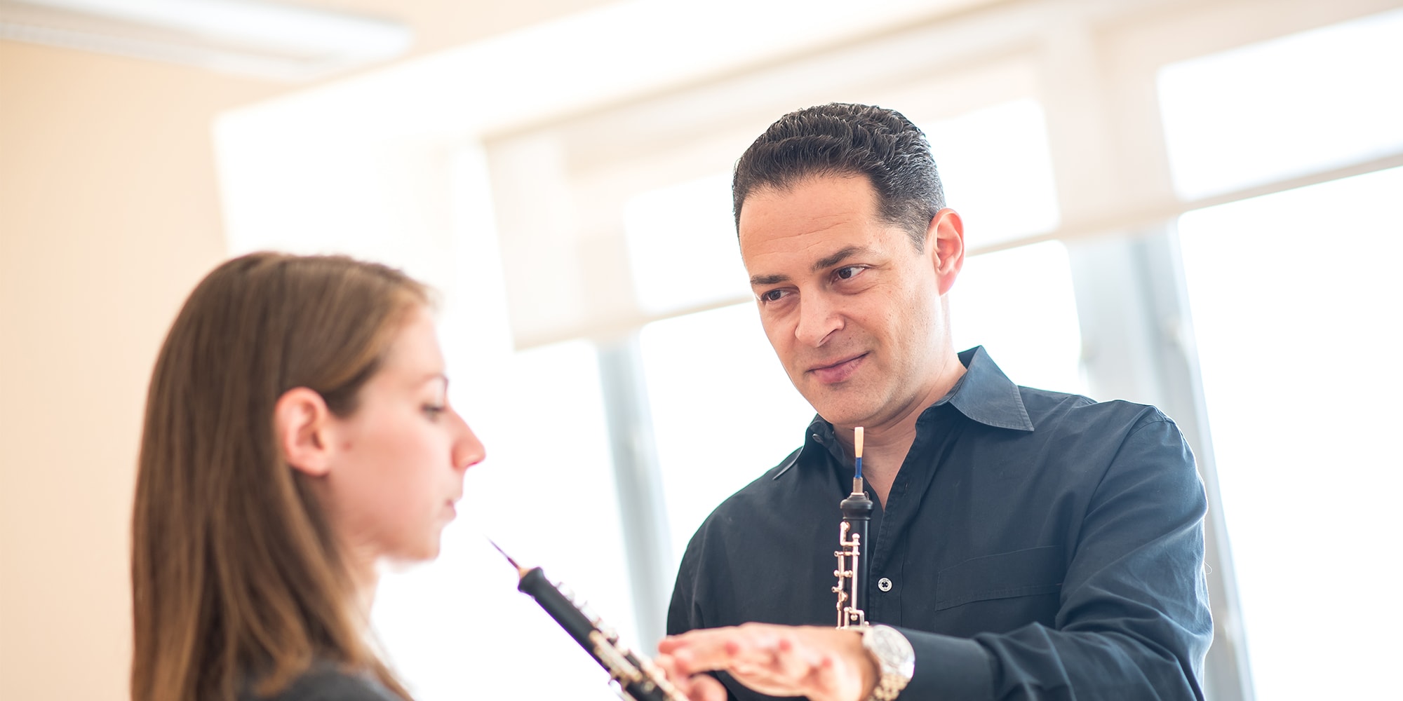 oboe sfcm faculty Eugene Izotov teaching a student in a bright classroom