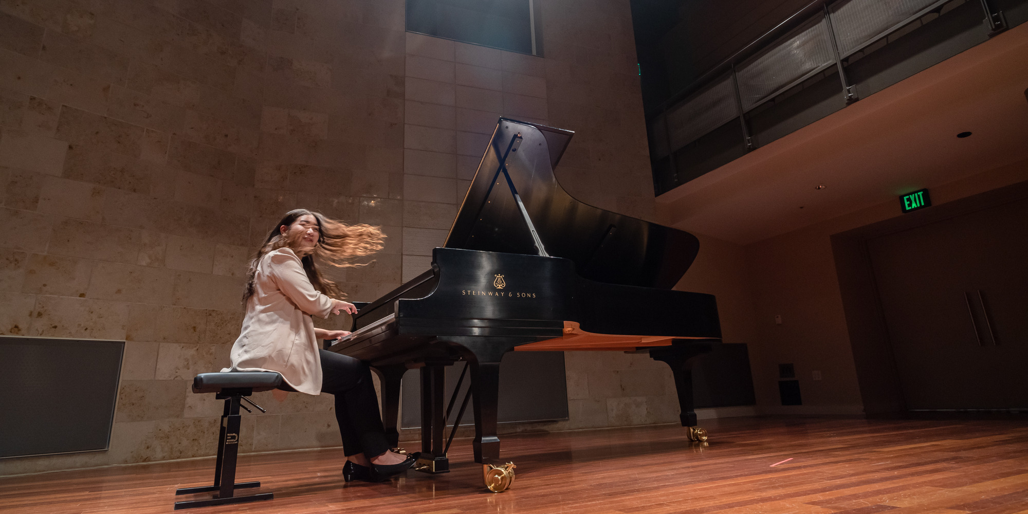 a student performing at the piano, hair is in motion