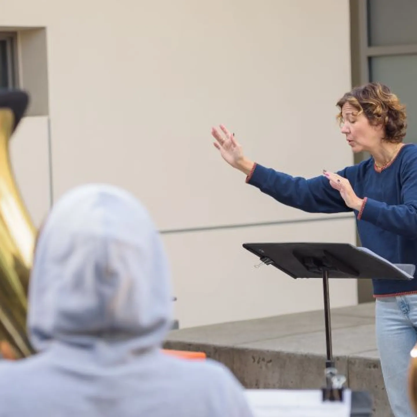 a teacher conducts a brass ensemble on the terrace of the AGC