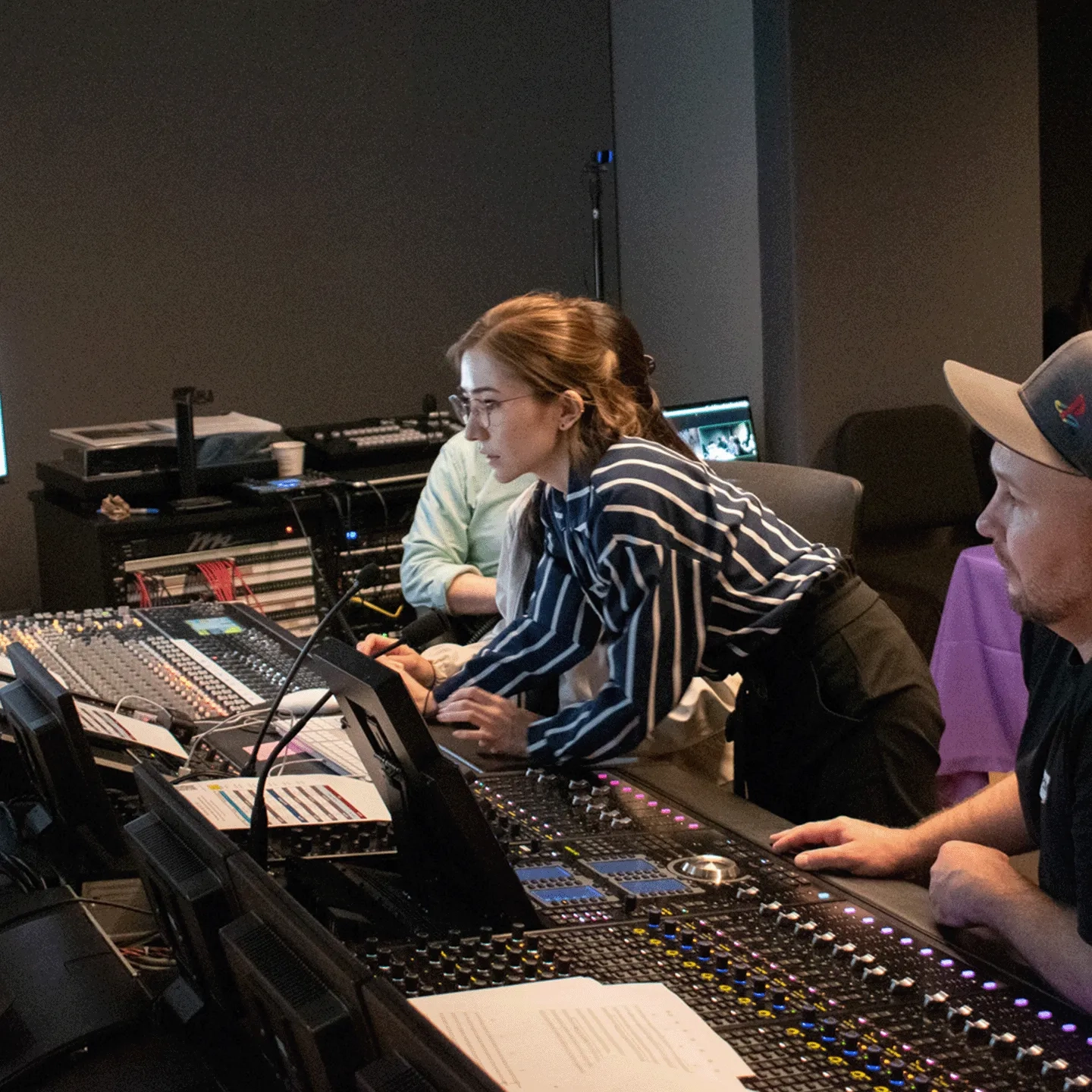 A student works with a mentor inside a recording studio.
