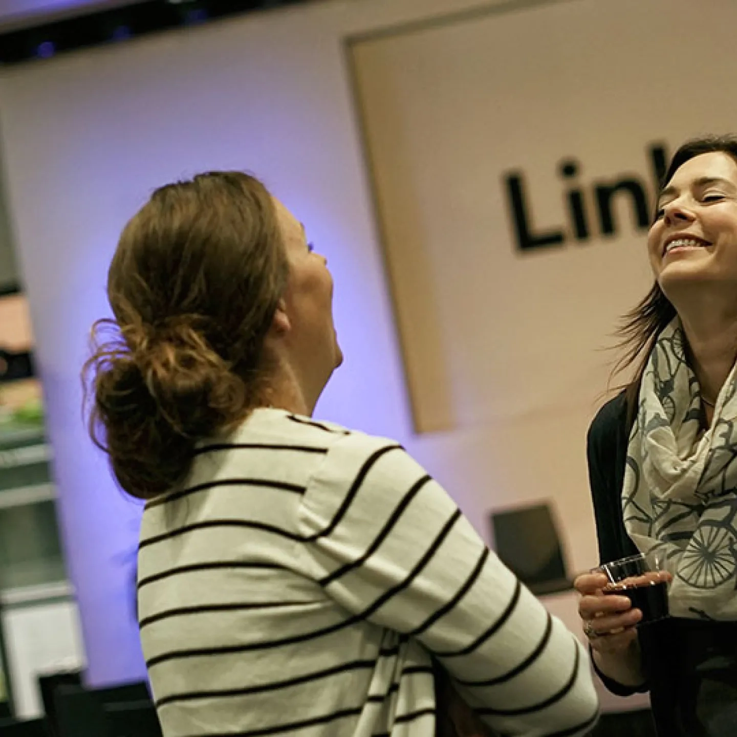 two people laughing over a glass of wine at a meetup