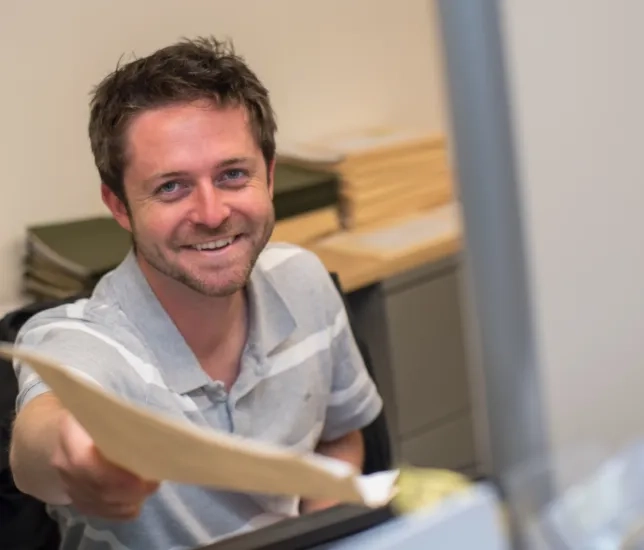 a man hands you a manila folder
