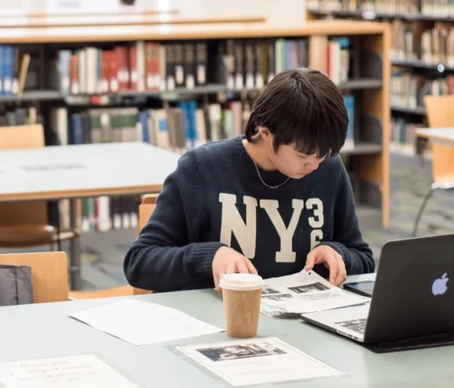 student in library studying on a computer