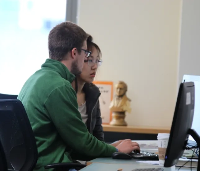 students sit at a computer 