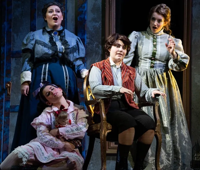 A group of students performing opera onstage, wearing old-fashioned costumes.