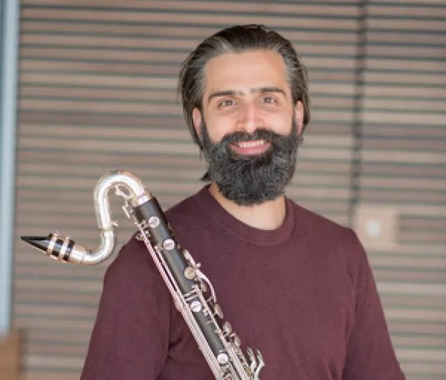 Jeff anderle smiling and holding a bass clarinet
