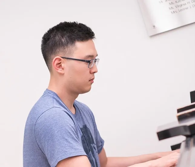 A photo of an adult extension student learning piano