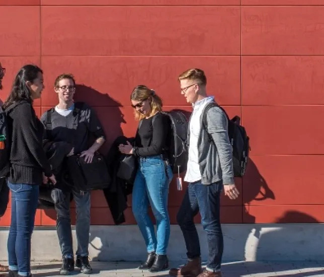 SFCM students in front of a red wall