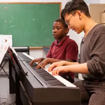 a teacher teaches at the piano