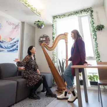 two students chat in a dorm room with instruments