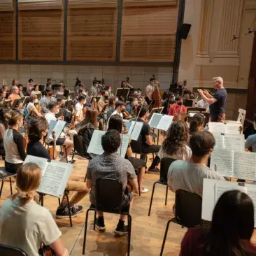 an orchestra rehearsal from behind the first violin section