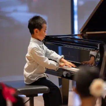 a young pianist performs at the piano