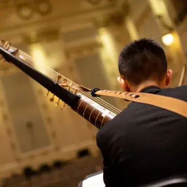 a student playing a historical instrument in the concert hall