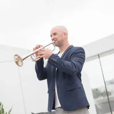 Adam Luftman on the rooftop of bowes playing the trumpet