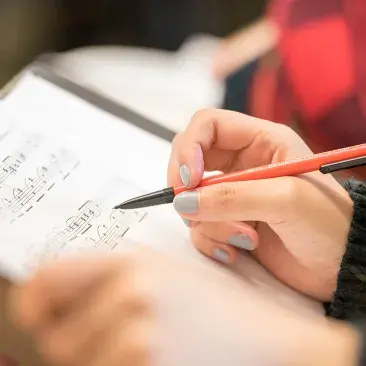 a close up of a pencil on sheet music