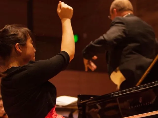 a pianist performs a concerto with the orchestra