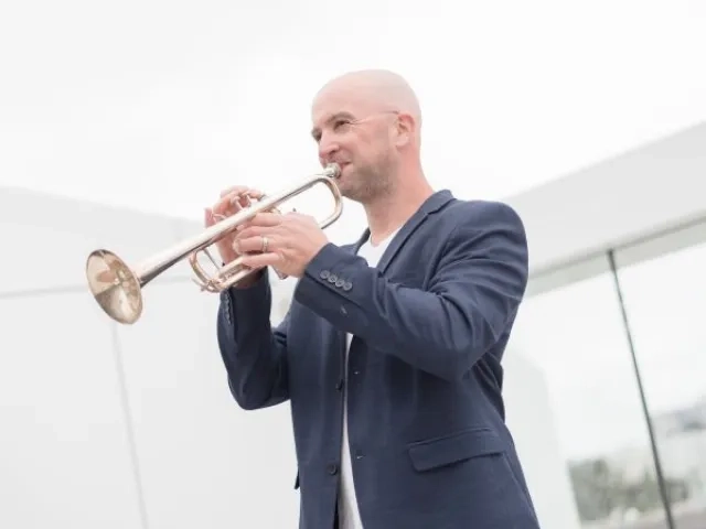 Adam Luftman on the rooftop of bowes playing the trumpet