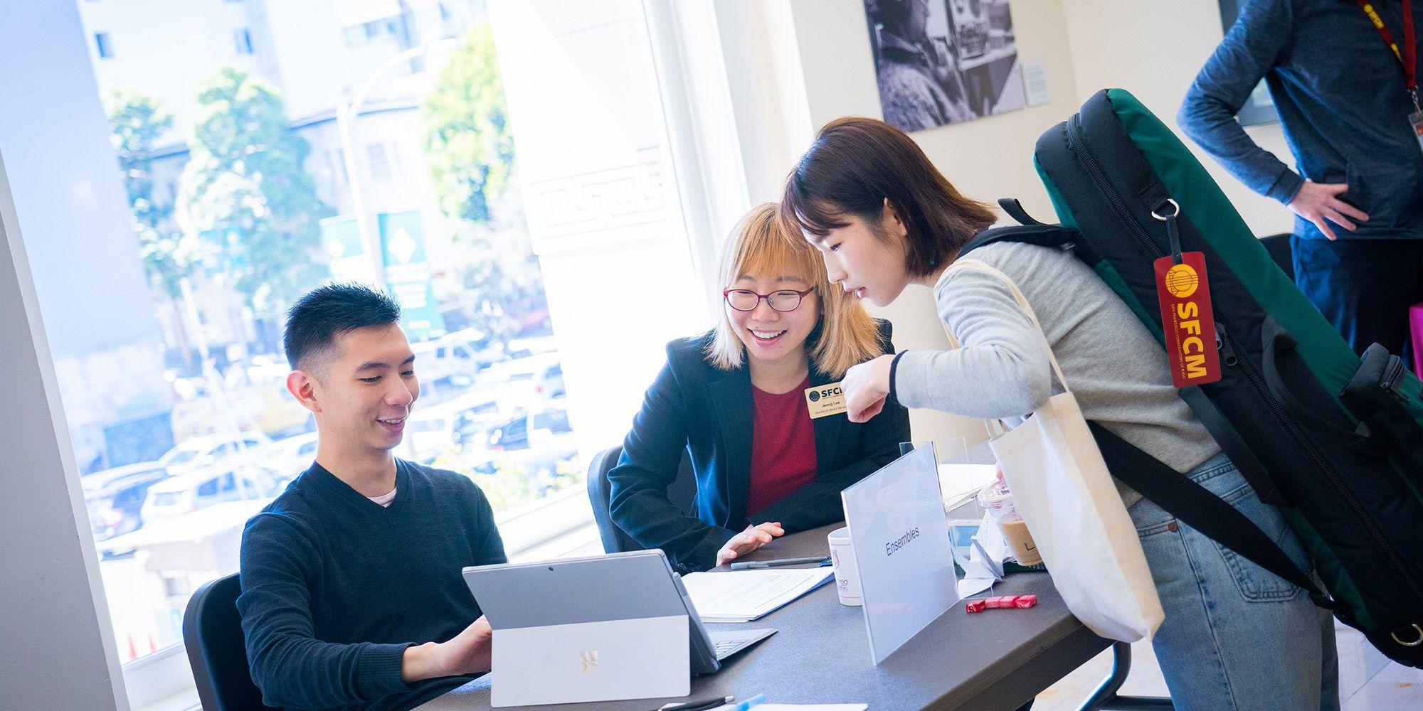 An SFCM student being helped by SFCM staff members
