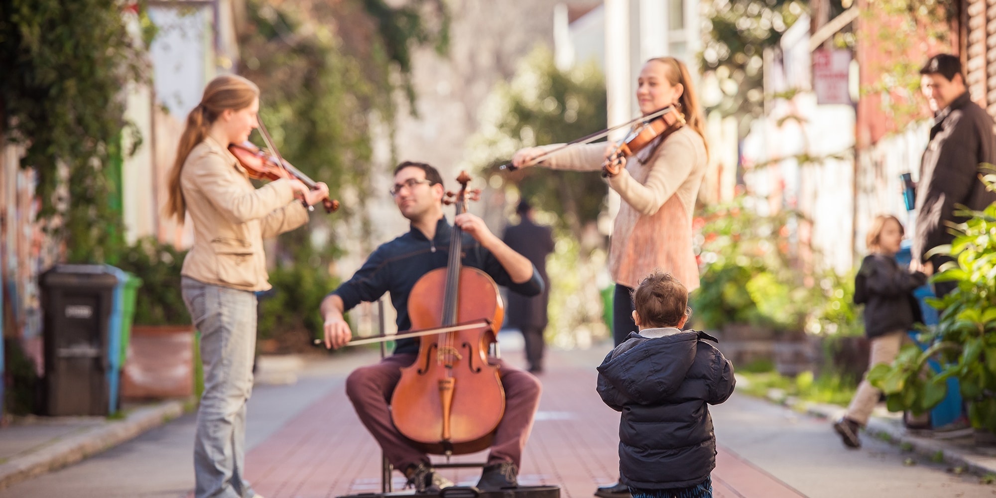 baby watching string trio performing in courtyard cello viola violin