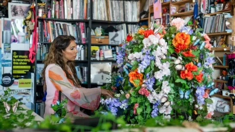 Lara downes plays a tiny desk concert surrounded by flowers