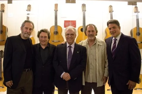 Serrge Assad, David Tanenbaum, Romero, John Harris, and David Stull in front of guitar collection