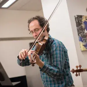 Joseph Maile headshot while playing violin