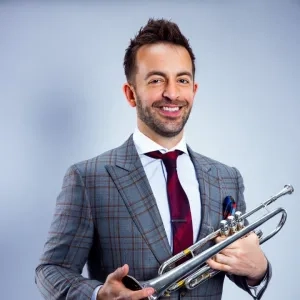 Benny Benack iii headshot with his trumpet