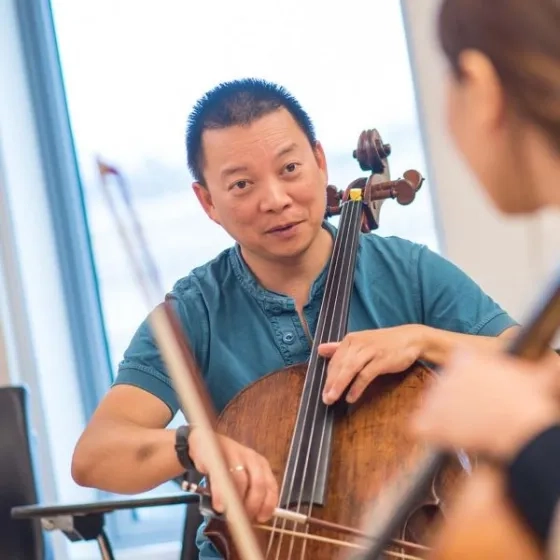 Amos Yang teaches a lesson on the cello