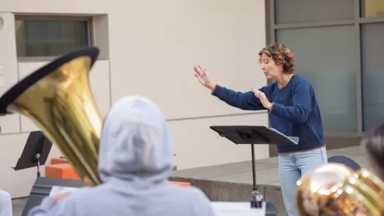 a teacher conducts a brass ensemble on the terrace of the AGC