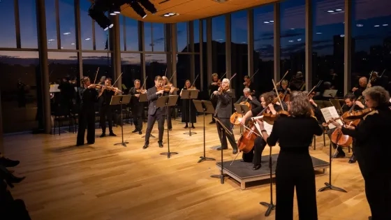 students play side by side with the academy orchestra at st martin in the fields, during sunset on the 11th floor recital hall of Bowes