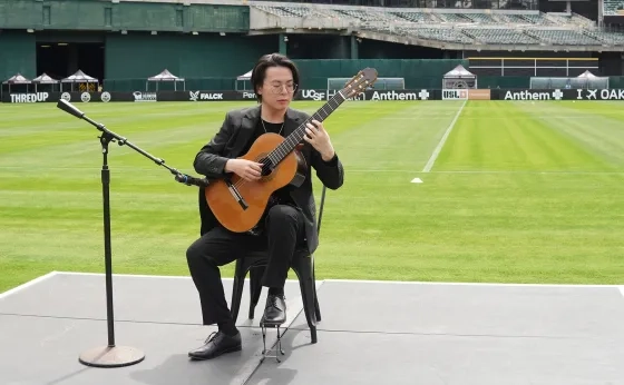 Mario To performing on guitar. 