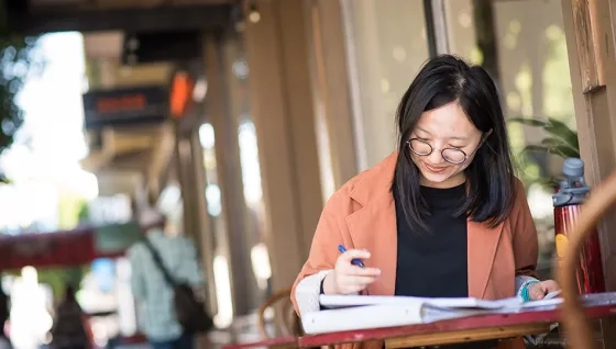 student working in a binder at a small table