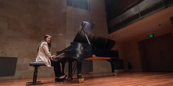 A pianist sits at the piano in the recital hall