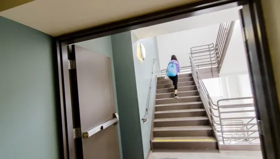 SFCM student walking up stairs inside 50 Oak building in San Francisco