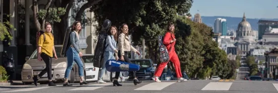 SFCM students walking outside with instruments in cases