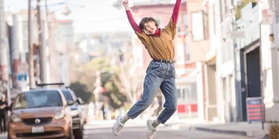 Student jumping up in excitement while outside