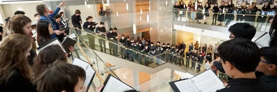 Pre-College Students singing inside SFCM. students wrapped around 2nd floor and down staircase