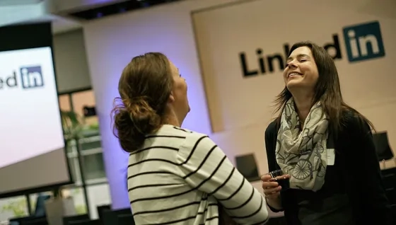 two people laughing over a glass of wine at a meetup