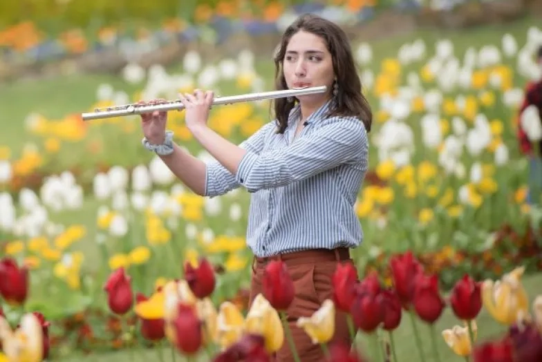 a flute student plays outside among the tulip gardens in san francisco