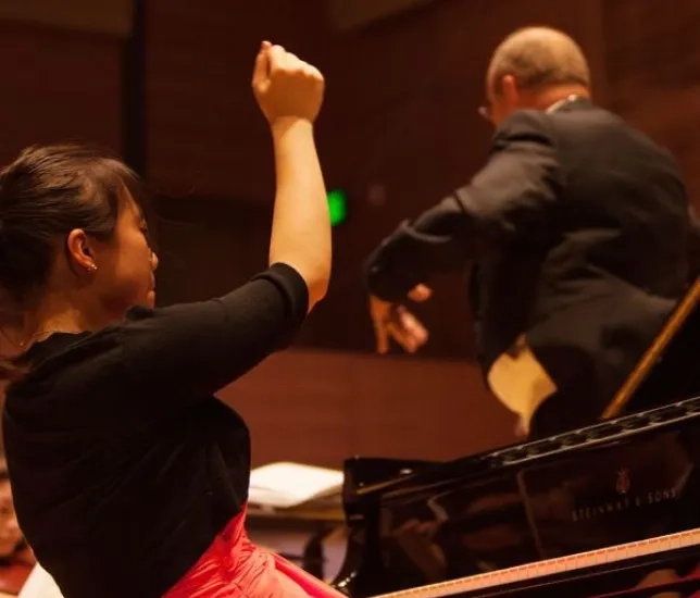 a pianist performs a concerto with the orchestra