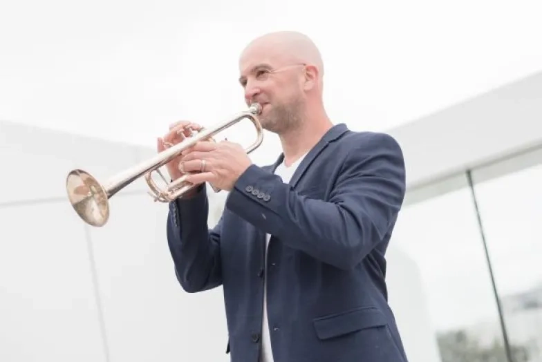 Adam Luftman on the rooftop of bowes playing the trumpet