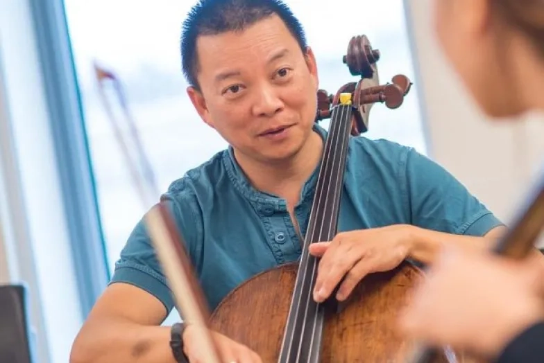 Amos Yang teaches a lesson on the cello