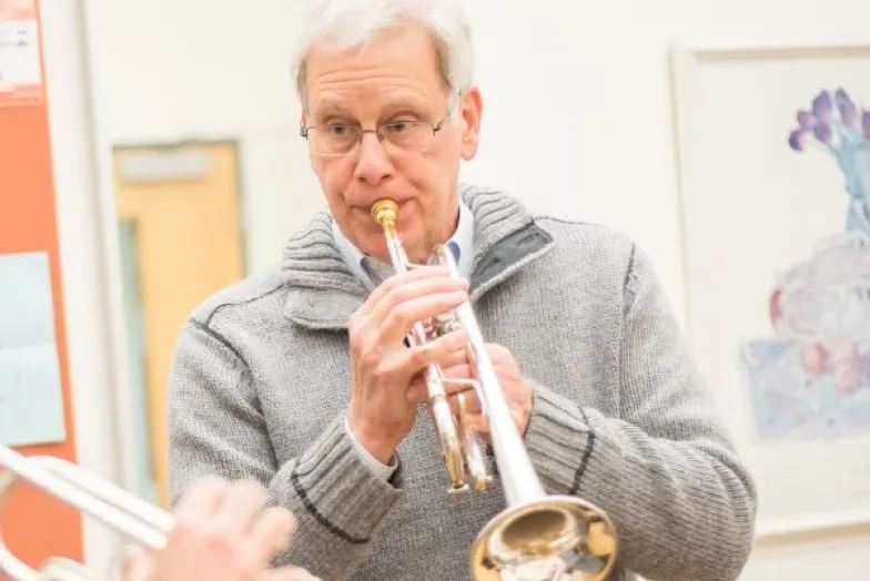 David Burkhart headshot playing trumpet