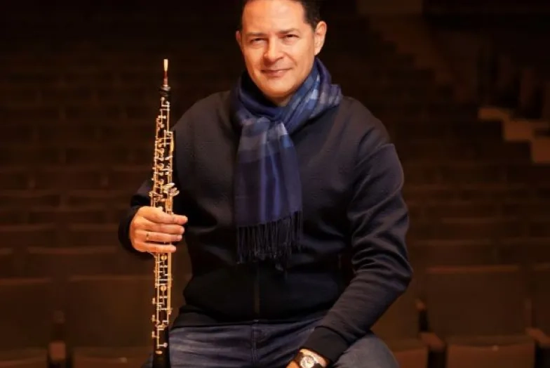 Eugene Izotov headshot while holding an oboe