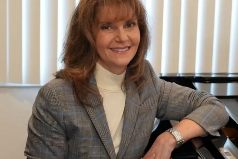 Lena Schuman headshot while sitting at piano