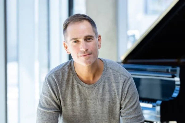 Matthew Worth headshot while sitting at piano